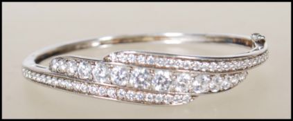 A stamped 925 silver bangle having three rows of graduating CZ's. Interior diameter 6cm. Weight 18.