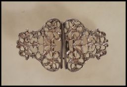 A silver hallmarked nurses belt buckle having pierced fretwork decoration with scrolled foliate