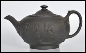 A 19th Century Victorian Wedgwood Jasperware black basalt teapot and cover having relief decorated