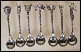 A selection of pewter tea spoons each having African animal head finials and twisted stems. Makers