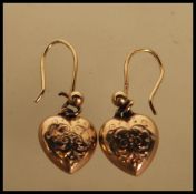 A pair of 9ct gold hallmarked heart shaped 20th Century drop earrings each with chase decorated