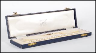 A vintage pearl necklace having a decorative 9ct white gold clasp with illusion set and single white