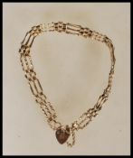 A stamped 375 9ct gold heart lock bracelet with a fancy link chain. Weight 5.5g. Assay marks for