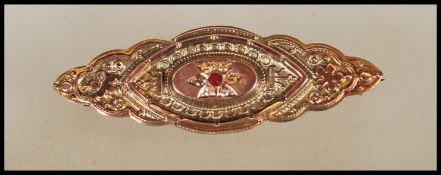 A stamped 9ct gold 19th Century Victorian mourning brooch of symmetrical patterned form set with a