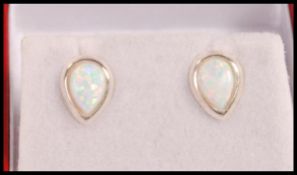 A pair of silver stud earrings set with pear shape