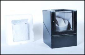 A contemporary leather housed single cushion automatic watch winder, hinged top with single