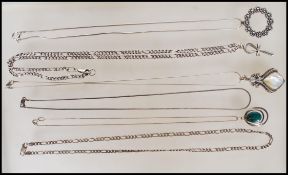 A selection of silver necklaces to include a snake chain with a circular wreath pendant, a figaro