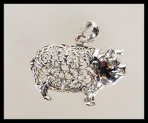 A silver stamped sterling pendant necklace in the form of a pig having a filigree decorated body