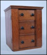 A 20th Century miniature travelling Wellington chest having a bank of three drawers with turned