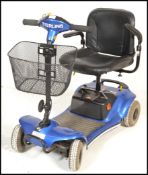A Sterling Pearl mobility scooter having a blue painted body on four wheels with a black leather