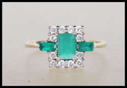 A 9ct gold hallmarked Art Deco style dress ring, the central polished green stones of lozenge form