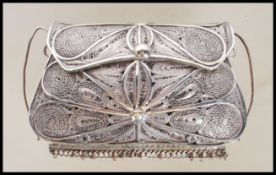 A 20th Century unmarked silver white metal filigree purse having a hinged lid clasp with tassels