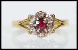 A hallmarked 18ct yellow gold ladies dress ring set with a round cut garnet with a halo of