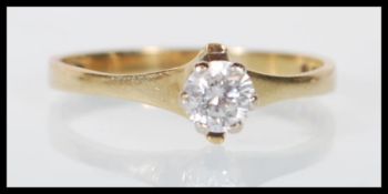 A hallmarked 9ct yellow gold single solitaire white stone ring on a split mount. English hallmarks