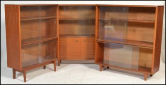 A set of three retro 20th Century teak wood glazed bookcases, each bookcase having sliding glass