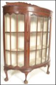 A 1920's bow front - demi lune Queen Anne mahogany display cabinet. Raised on claw and ball feet