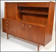A mid century Danish inspired teak wood sideboard / highboard credenza being raised on tapering legs