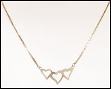 A hallmarked 9ct pendant in the form of three linked hearts on a 9ct gold box link chain having a
