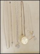 A small group of silver necklace chains and pendants to include a fine link chain having a dragonfly