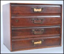An early 20th century mahogany desk top filing cabinet having flared top over 4 drawers with brass