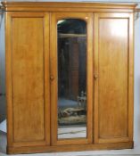 A 19th century Victorian ash triple wardrobe linen press compactum. Raised on a plinth base with a