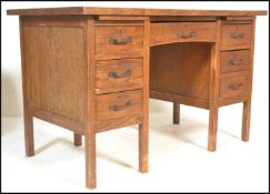 An early 20th Century Air Ministry style oak twin pedestal desk raised on square supports with a