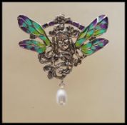A stamped 925 silver necklace pendant / brooch depicting a central lady with plique a jour wings