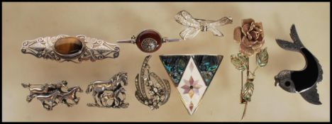 A selection of silver brooches to include a pierced and engraved decorated brooch set with a central