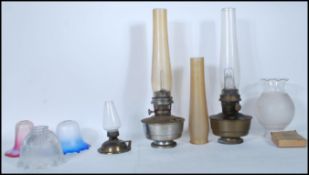 Two vintage oil lamps. One with copper base and clear glass chimney, other steel, with opaque