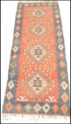 A vintage 20th Century woolen kilim rug having a blue ground with a central red panel with geometric