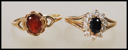 A hallmarked 9ct gold ring set with an oval cut garnet having pierced shoulders in the form of