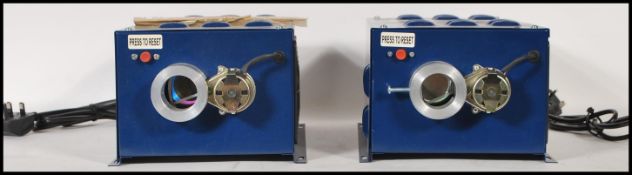 A pair of Home Automation Studio 3 home lighting machines, blue metal case with lens to front. Model