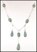 An unmarked but test as 9ct gold necklace having orbs set with with turquoise fragments with wire