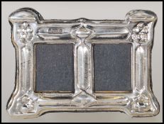 A silver hallmarked Art Nouveau style easel back double photo frame of rectangular form.