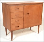 A 1970's retro teak wood singer sewing machine cabinet with fold over top and cabinet raised on