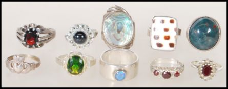 A selection of silver ladies dress rings to include an abalone shell set ring, a ring set with an