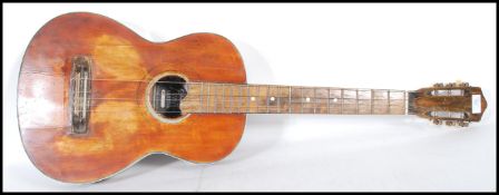 A 20th Century Columbia Junior six string acoustic guitar having a rustic varnished body with
