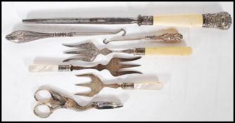 A small group of flatware and other tools to include three toasting forks having silver collars with