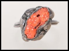 A late 19th / early 20th Century Art Nouveau silver ring set with a coral panel carved with