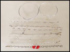 A selection of stamped silver bracelets to include two spacer bracelets set with oval cut white