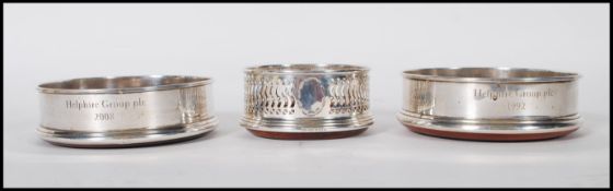 A pair of M C Hersey & Son silver hallmarked wine coaster having a Sapele mahogany base with a