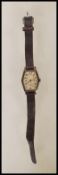 An Art Deco hallmarked silver watch with leather strap having an engine turned face with