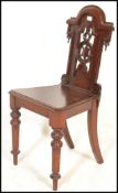 A 19th Century Victorian mahogany hall chair, with pierced back with scrolling decoration, raised on