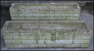 A pair of 20th Century well weather reconstituted garden planters of rectangular trough form,