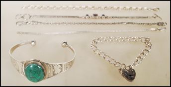 A group of silver bracelets to include a silver bangle having engraved decoration and a central