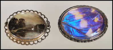 An early 20th Century silver brooch of oval form set with an iridescent butterfly wing panel