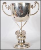 A silver Chinese trophy having twin handles, the large bowl raised on squash rackets. Notation to