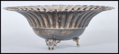 A silver 925 bon bon dish with scalloped edges being raised on a tripod leg base. Stamped 925 to