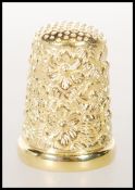 A stamped 925 sterling silver and gold plate thimble having floral decoration. Weighs 9.9g. Measures