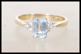 An English hallmarked 9ct gold ladies dress ring set with a rectangular blue topaz stone flanked